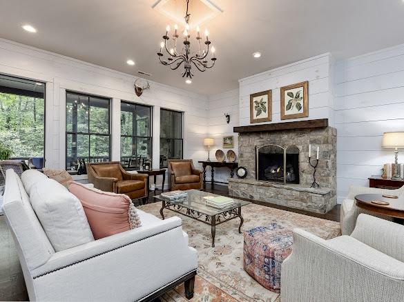 11 Feldspar Ln, Sapphire, NC 28774 - living room with a chandelier, ornamental molding, recessed lighting, a stone fireplace, and wood finished floors
