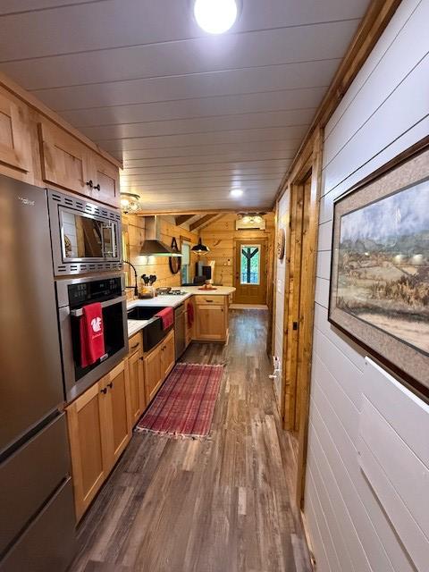 26 S Cumberland Dr, Lake Toxaway, NC 28747 - kitchen with stainless steel appliances, dark wood-style floors, wood walls, and wall chimney range hood