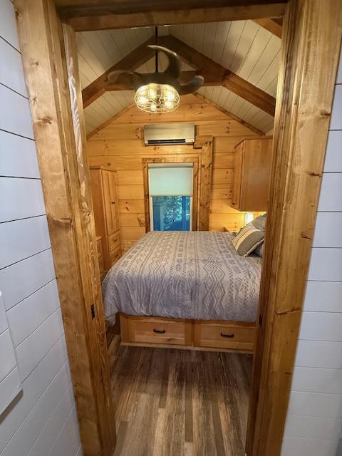 26 S Cumberland Dr, Lake Toxaway, NC 28747 - bedroom with a wall mounted AC, wood finished floors, and wood walls