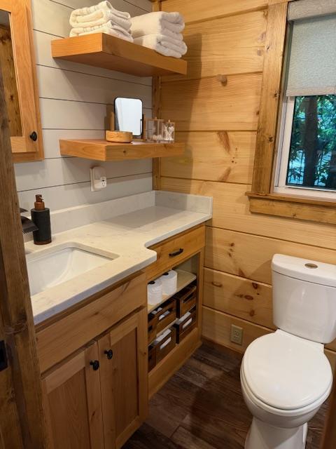 26 S Cumberland Dr, Lake Toxaway, NC 28747 - half bathroom with vanity, toilet, wood finished floors, and wooden walls