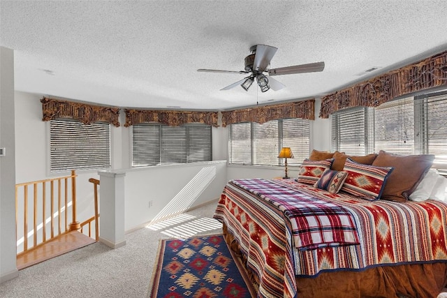 carpeted bedroom featuring ceiling fan and a textured ceiling