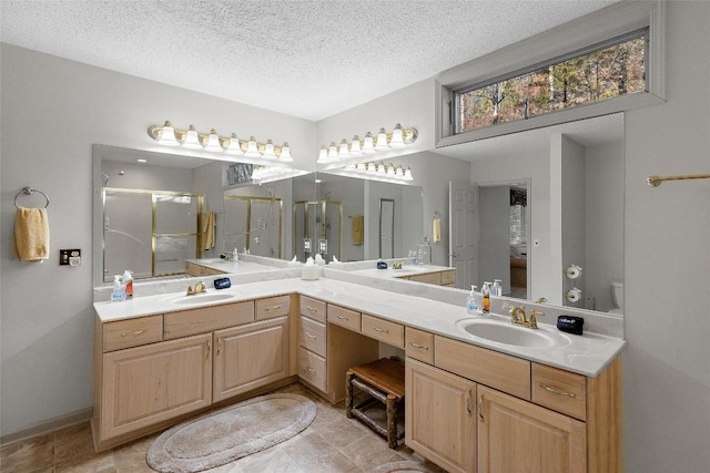 bathroom with vanity, toilet, an enclosed shower, and a textured ceiling