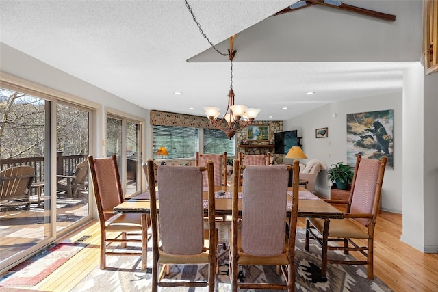 dining room featuring an inviting chandelier, hardwood / wood-style floors, and a textured ceiling