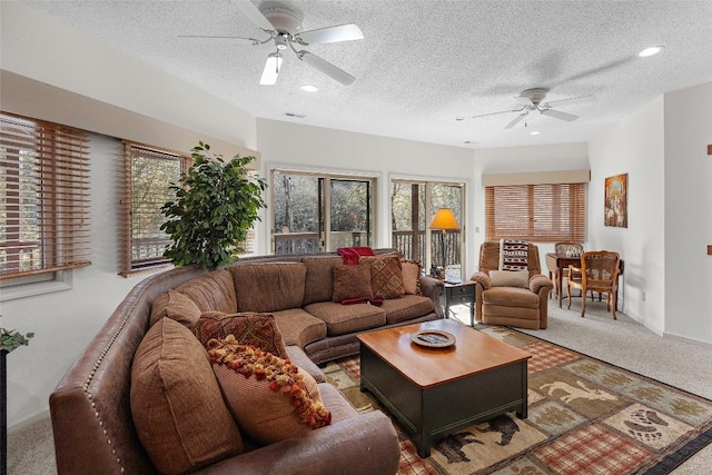 carpeted living room with a textured ceiling and ceiling fan