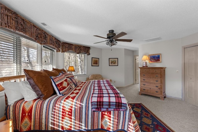 carpeted bedroom with ceiling fan and a textured ceiling