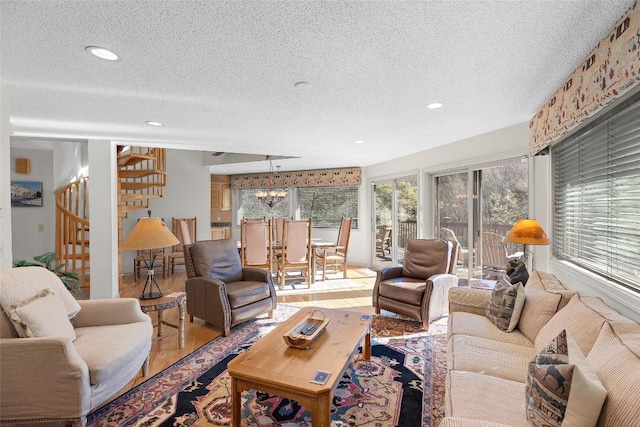 living room featuring hardwood / wood-style floors, a textured ceiling, and a notable chandelier