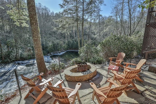 view of patio / terrace featuring a water view and a fire pit