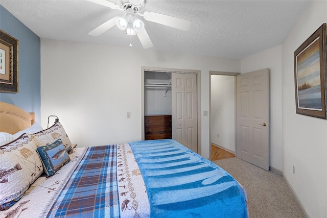 carpeted bedroom with ceiling fan, a textured ceiling, and a closet