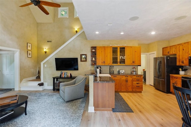 132 Azalea Ct, Sapphire, NC 28774 - kitchen featuring freestanding refrigerator, a ceiling fan, light wood-style floors, tasteful backsplash, and brown cabinets