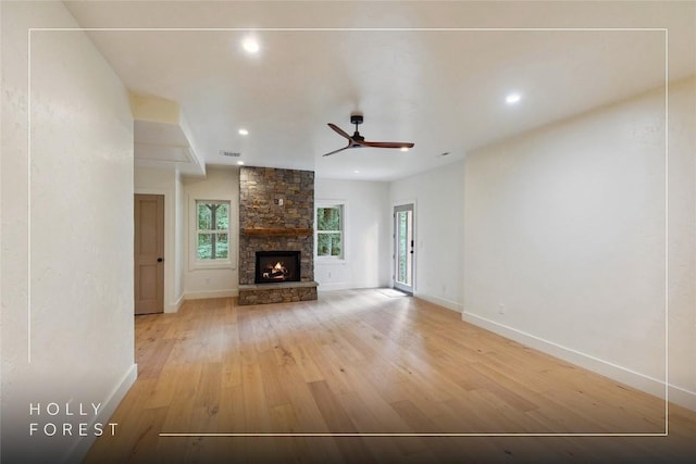 132 Azalea Ct, Sapphire, NC 28774 - unfurnished living room featuring healthy amount of natural light, light wood-style flooring, a stone fireplace, ceiling fan, and recessed lighting