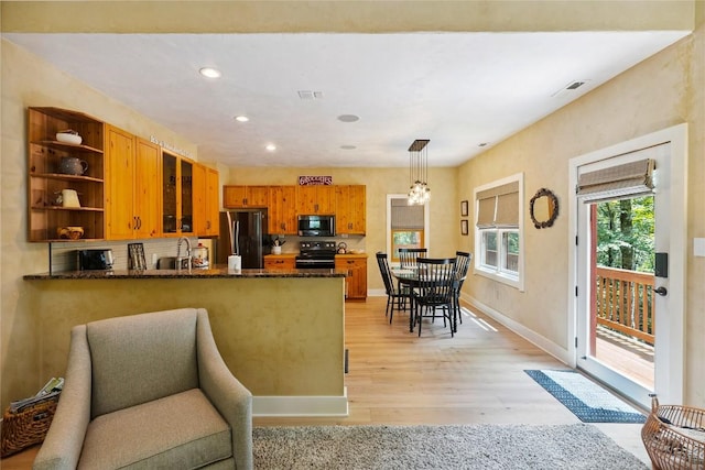 132 Azalea Ct, Sapphire, NC 28774 - kitchen with black appliances, a peninsula, open shelves, light wood-style flooring, and brown cabinetry