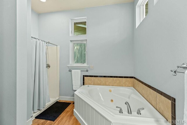 bathroom featuring shower with separate bathtub and hardwood / wood-style floors