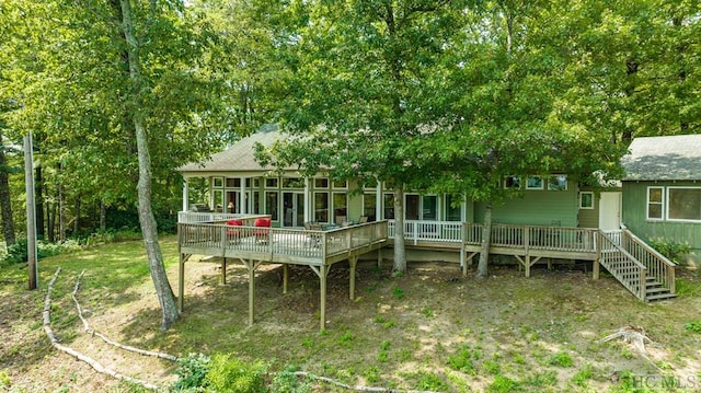 rear view of house with a deck and a sunroom