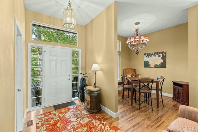 entrance foyer with a notable chandelier and light wood-type flooring