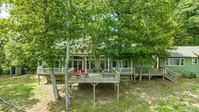 rear view of house featuring a wooden deck