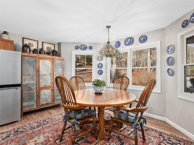 dining area featuring plenty of natural light, baseboards, and wood finished floors