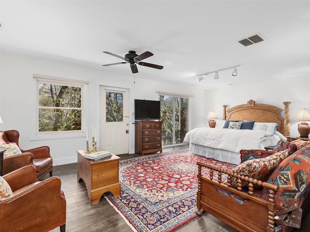 bedroom with baseboards, visible vents, dark wood finished floors, and a ceiling fan