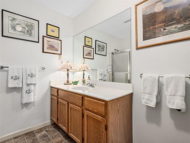 full bath with a shower with door, baseboards, visible vents, and vanity