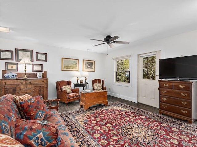 living room featuring ceiling fan, baseboards, and wood finished floors