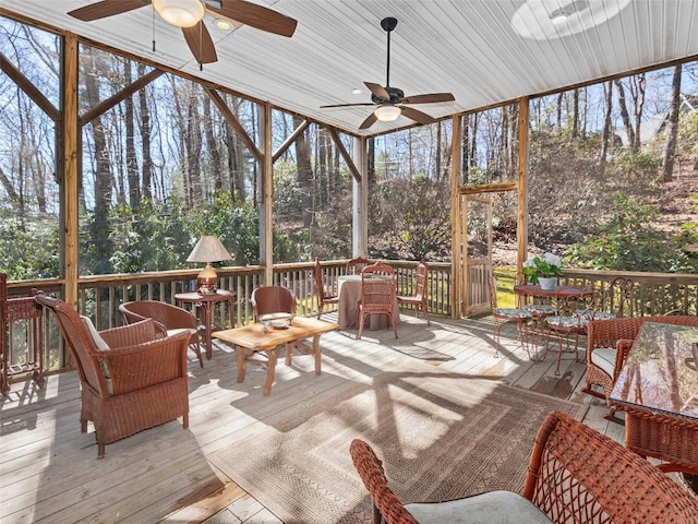 sunroom / solarium featuring outdoor dining space, a ceiling fan, and a healthy amount of sunlight