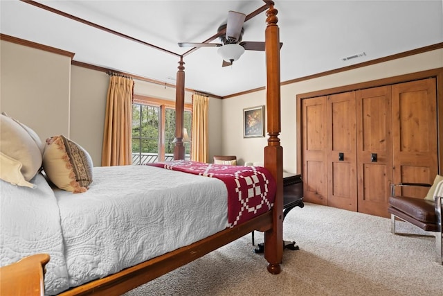 carpeted bedroom with ornamental molding, ceiling fan, and a closet
