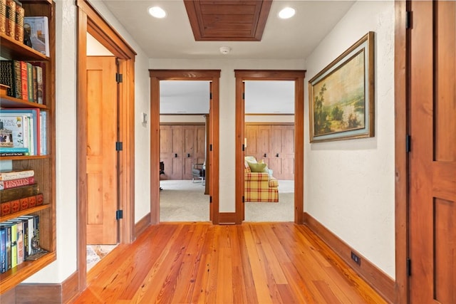 corridor with light wood-style flooring, baseboards, and recessed lighting