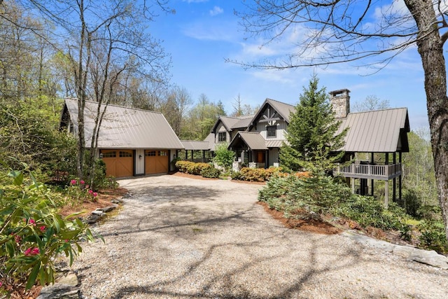 view of front of property with a chimney, metal roof, an outbuilding, and dirt driveway