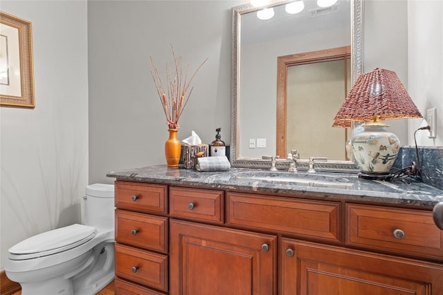 half bath featuring toilet and vanity