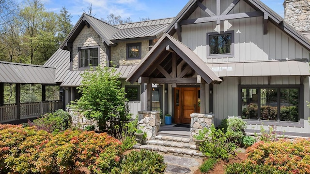 modern farmhouse style home with a standing seam roof, a chimney, metal roof, and board and batten siding