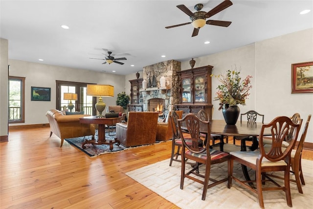 dining room with ceiling fan, light wood-type flooring, recessed lighting, a fireplace, and baseboards