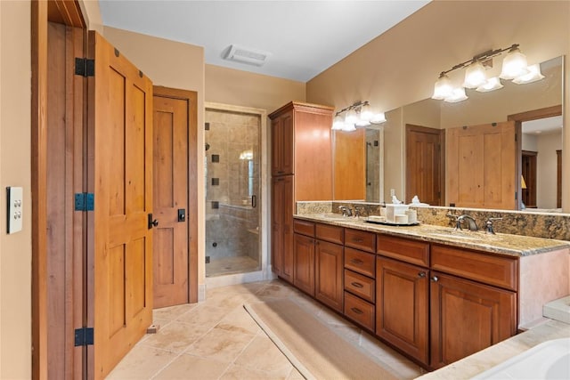 bathroom with a shower stall, double vanity, and tile patterned flooring