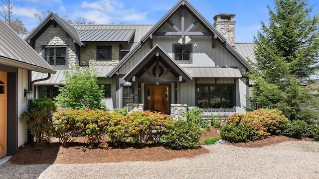 view of front facade featuring a standing seam roof, metal roof, and a chimney