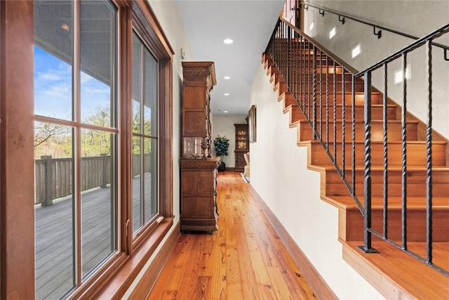 hall with hardwood / wood-style floors, plenty of natural light, stairway, recessed lighting, and baseboards