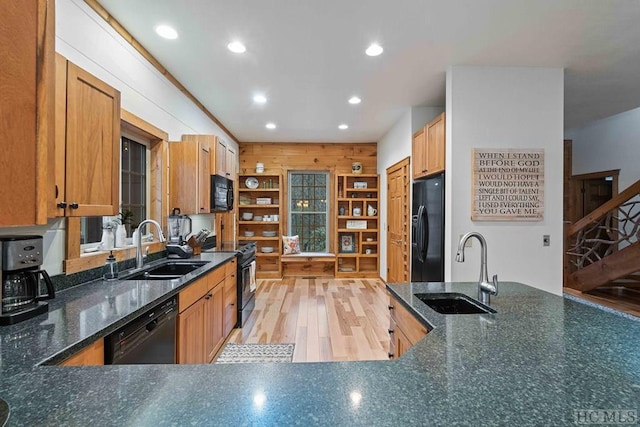 kitchen with sink, black appliances, and light hardwood / wood-style flooring