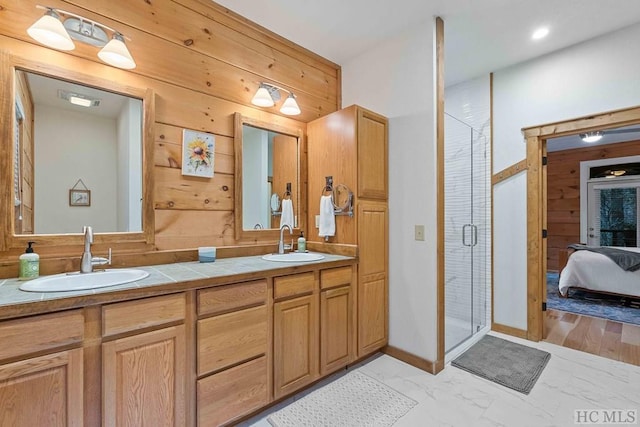 bathroom with wooden walls, vanity, and an enclosed shower