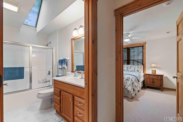 full bathroom with toilet, shower / bath combination with glass door, a skylight, ceiling fan, and vanity