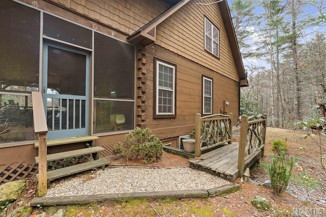 exterior space featuring a sunroom and a wooden deck