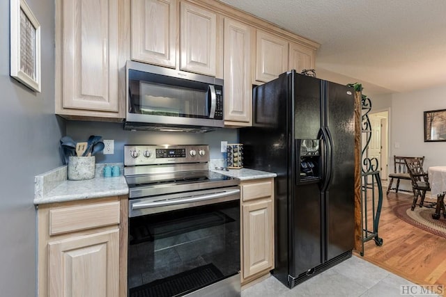 kitchen featuring stainless steel appliances, light brown cabinets, and light wood-type flooring