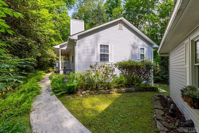 view of home's exterior with a porch and a lawn