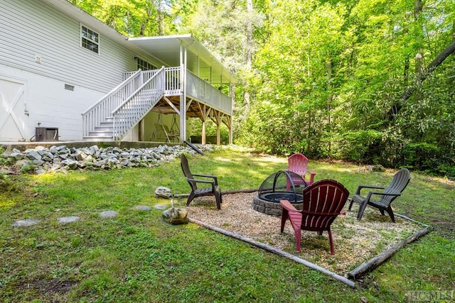 view of yard featuring a wooden deck and a fire pit