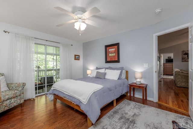 bedroom featuring dark wood-type flooring, access to outside, and ceiling fan