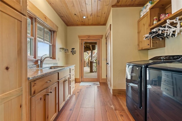 clothes washing area featuring cabinet space, washing machine and dryer, wood ceiling, light wood-style floors, and baseboards
