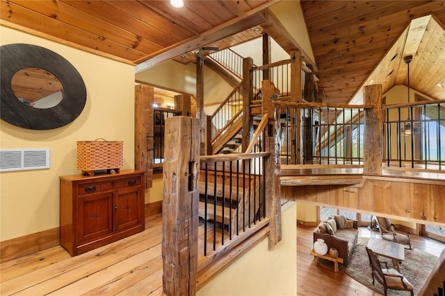 stairway with hardwood / wood-style floors, wooden ceiling, lofted ceiling, and baseboards