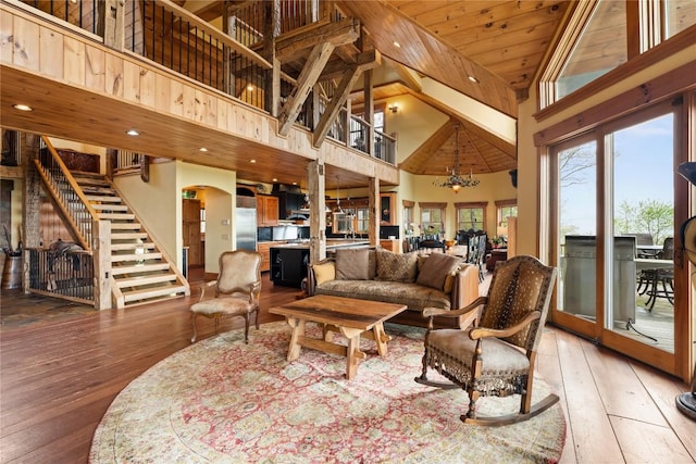 living room with high vaulted ceiling, stairway, light wood finished floors, wood ceiling, and arched walkways