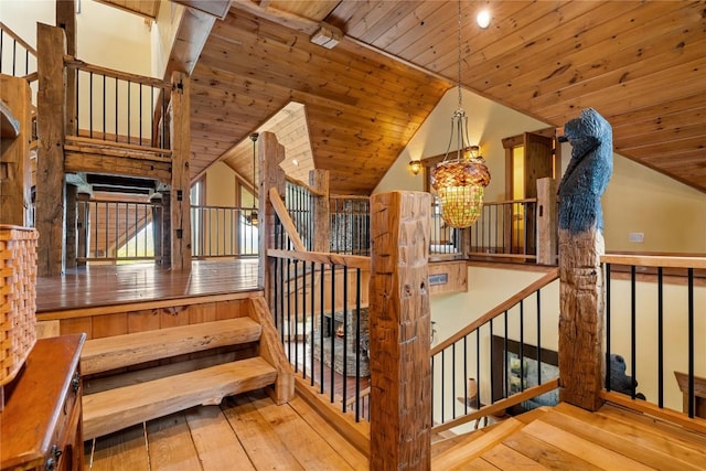 stairway with hardwood / wood-style flooring, a chandelier, lofted ceiling, and wood ceiling