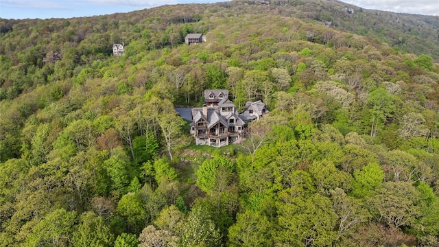 aerial view of property and surrounding area with a heavily wooded area