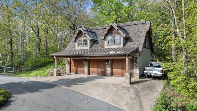 rustic home with a standing seam roof, stone siding, metal roof, and driveway