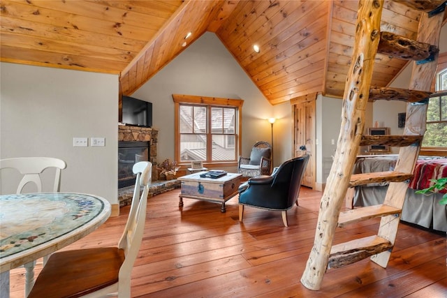 living area with hardwood / wood-style flooring, vaulted ceiling, wooden ceiling, and a fireplace