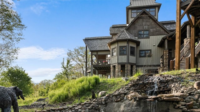 view of front of home featuring stairway and stone siding