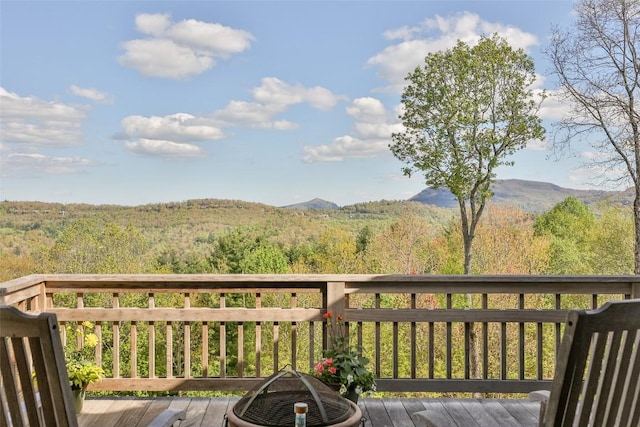 wooden terrace featuring a wooded view